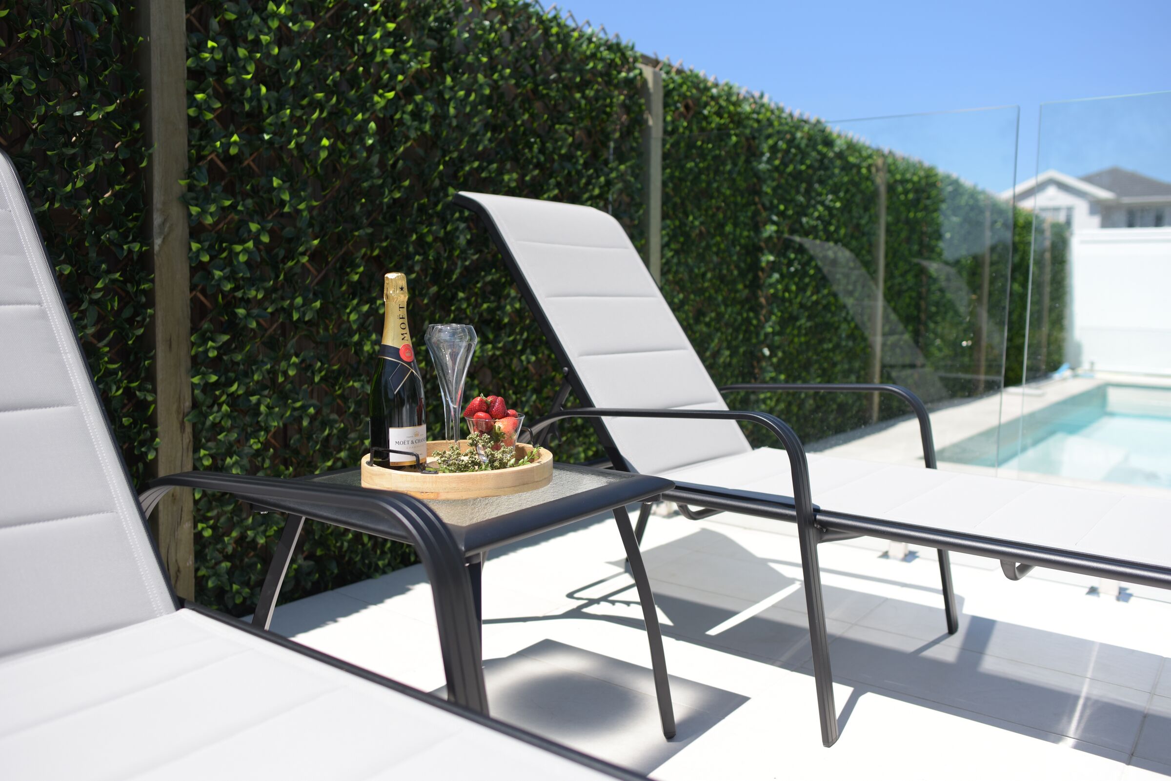 Leona Shelby sun lounges and side table beside a pool